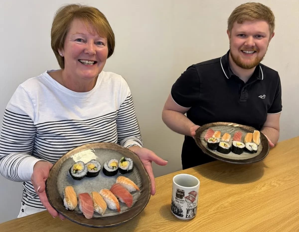 Mother and son shaping sushi rice together